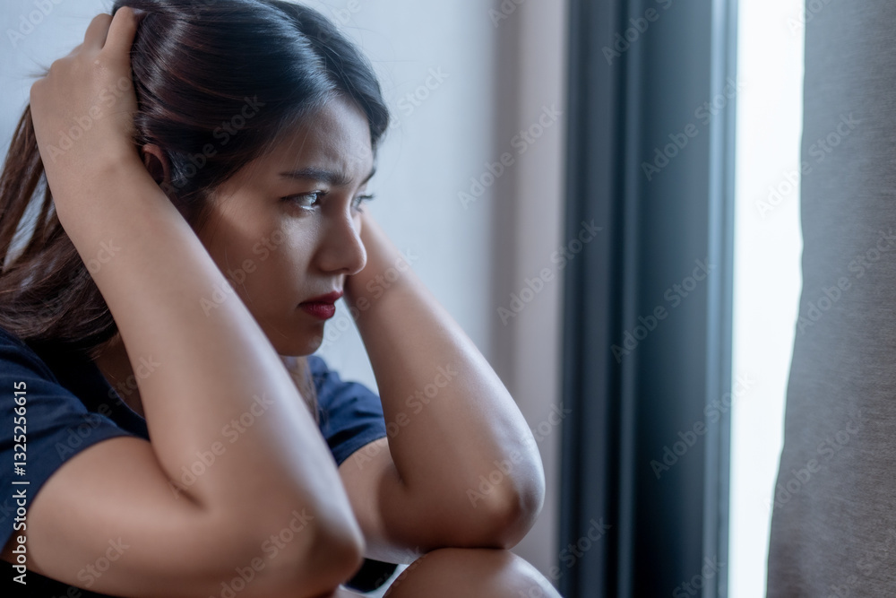 woman sitting by window, looking pensive and distressed, with her hands on her head. soft light creates contemplative atmosphere woman sitting by window, looking pensive and distressed, with her hands on her head. soft light creates contemplative atmosphere