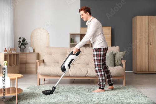 Young man cleaning carpet i...