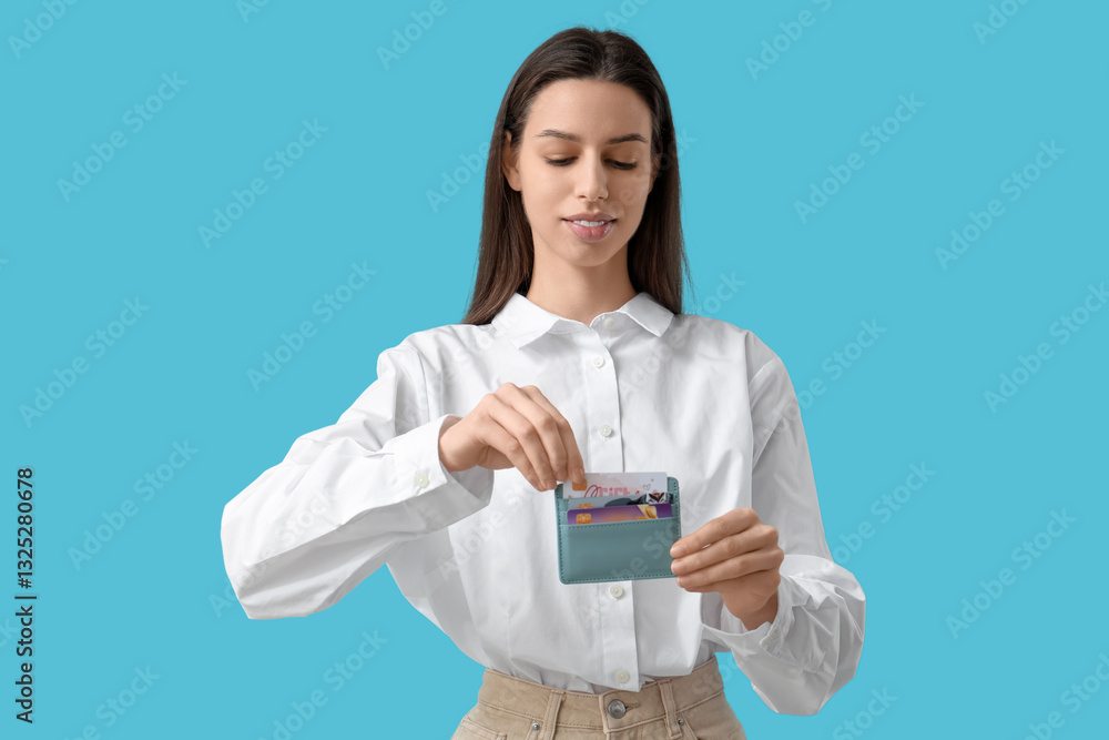 Woman with credit card holder on blue background Woman with credit card holder on blue background