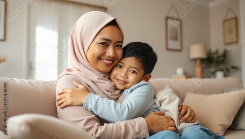 Wallpaper Mural Asian Muslim mom embraces and son sitting on couch in living room Torontodigital.ca