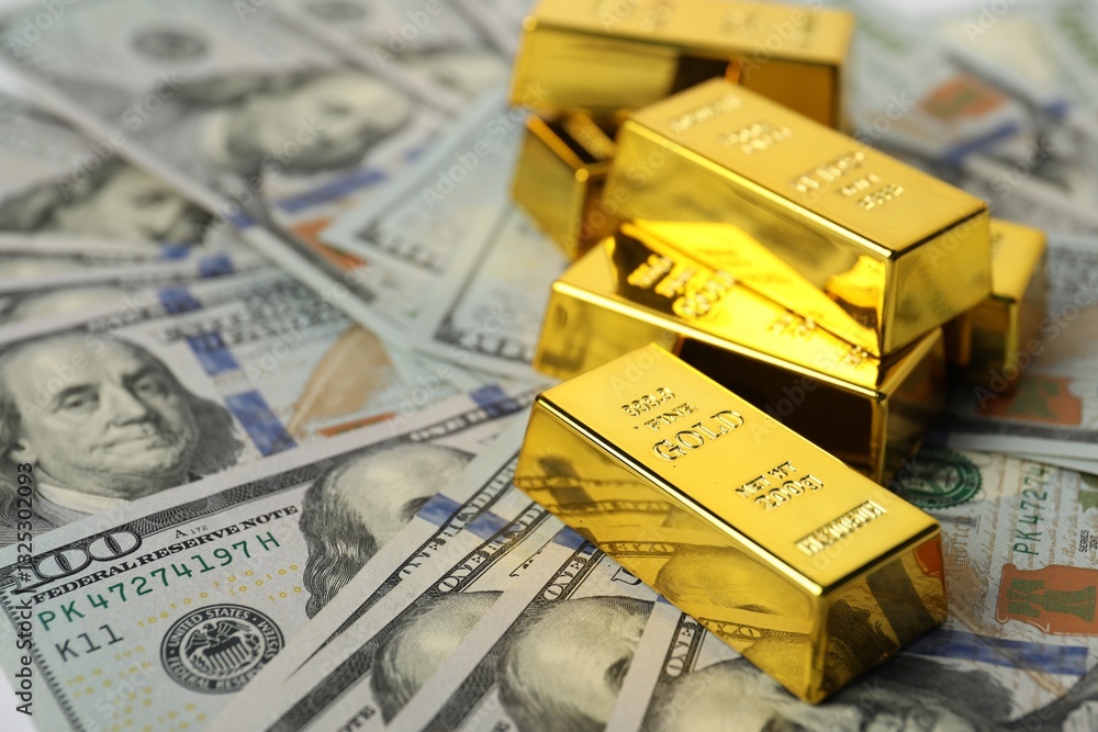 Shiny gold bars on dollar banknotes, closeup. Space for text Shiny gold bars on dollar banknotes, closeup. Space for text