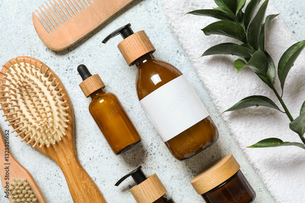 Fototapeta premium Composition with bottles of shampoo, hair brushes and green twig on white grunge background