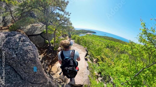 Three People Walk on Rocky Ledge in Acadia National Park
