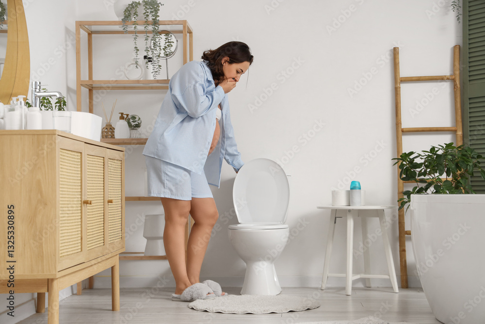 Pregnant woman with toxicosis near toilet bowl in bathroom Pregnant woman with toxicosis near toilet bowl in bathroom