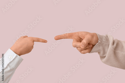 Tableau sur toile Hands of father and his son pointing at each other while squabbling on pink back