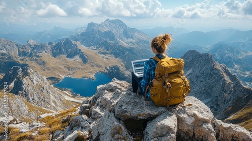 Mountain landscape with a person working on a laptop at an elevation during a clear day