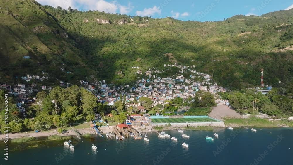 Aerial tilt down approach to Santa Catarina Palopo, Guatemala, traditional homes alongside Lake Atitlan Aerial tilt down approach to Santa Catarina Palopo, Guatemala, traditional homes alongside Lake Atitlan