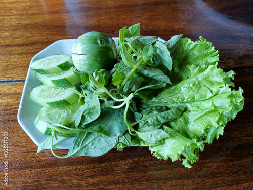 Fresh Green Vegetables on White Plate Cucumber, Eggplant, Lettuce and Herbs