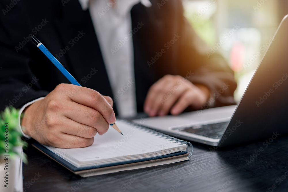 man hands with pen writing on notebook in the office.learning, education and work.writes goals, plans, make to do and wish list on desk.