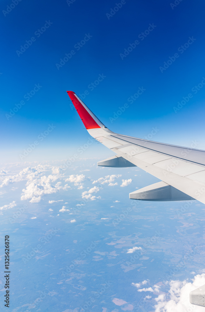 View from the airplane window at a beautiful cloudy sky and the airplane wing View from the airplane window at a beautiful cloudy sky and the airplane wing
