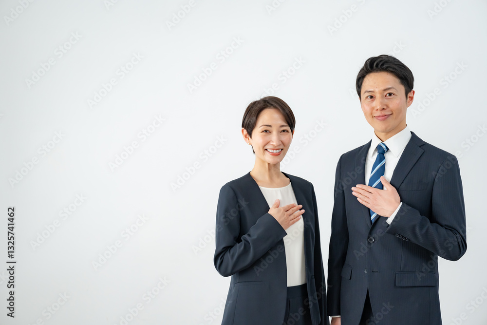 胸に手を当てるビジネスマン二人 胸に手を当てるビジネスマン二人