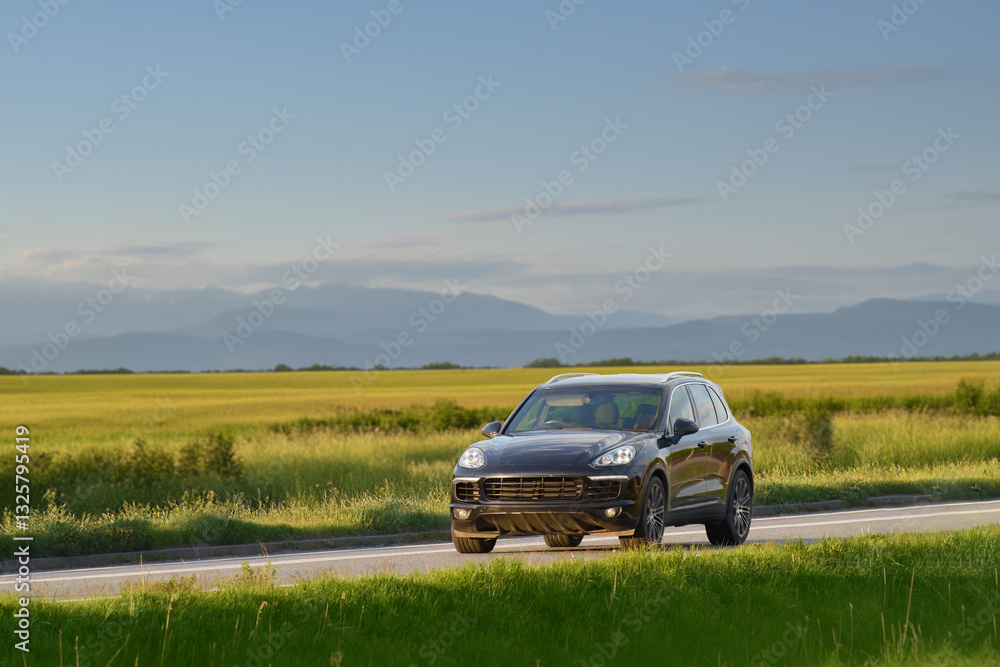 German black SUV driving on a scenic country road German black SUV driving on a scenic country road