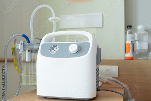Portable Phlegm Suction, Sputum suction machine from a tube in the throat of a patient who has undergone a tracheostomy surgery in hospital.