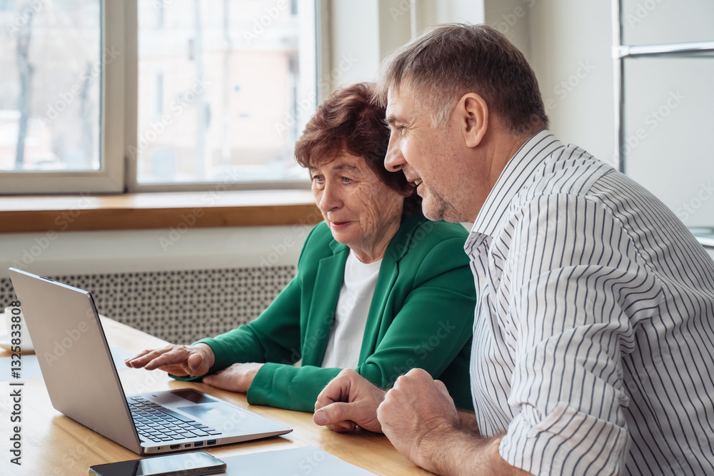 Male executive manager explaining corporate project online strategy to Senior female partner sitting at office desk. Male executive manager explaining corporate project online strategy to Senior female partner sitting at office desk.