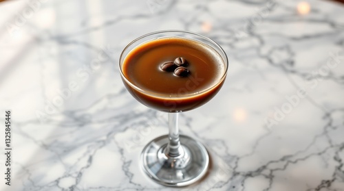 Elegant cocktail on marble: A stylish coffee concoction in a stemmed glass, garnished with coffee beans. photo