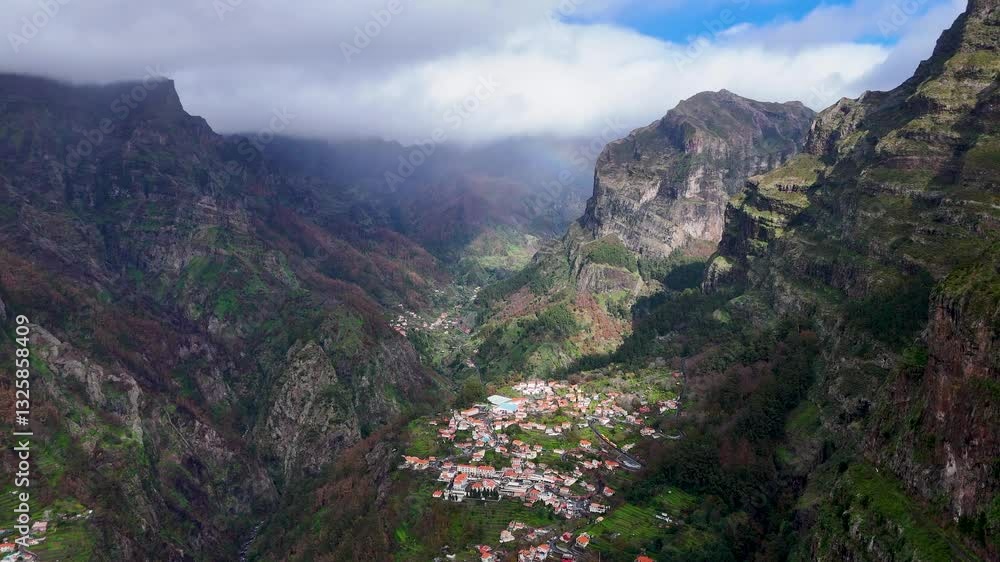 Side Aerial View of Curral das Freiras Mountain Village with a Vibrant Rainbow, Madeira Island, Portugal Side Aerial View of Curral das Freiras Mountain Village with a Vibrant Rainbow, Madeira Island, Portugal