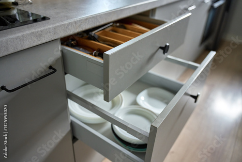 Obraz na płótnie Modern kitchen with dishes and cutlery in open drawers. Contemporary kitchen cabinets. Concept of home organization and functionality interior w salonie
