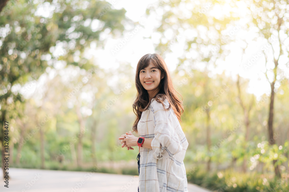 Asian woman enjoying summer outdoors, breathing fresh air with cheerful smile in sunny park surrounded by lush greenery Asian woman enjoying summer outdoors, breathing fresh air with cheerful smile in sunny park surrounded by lush greenery