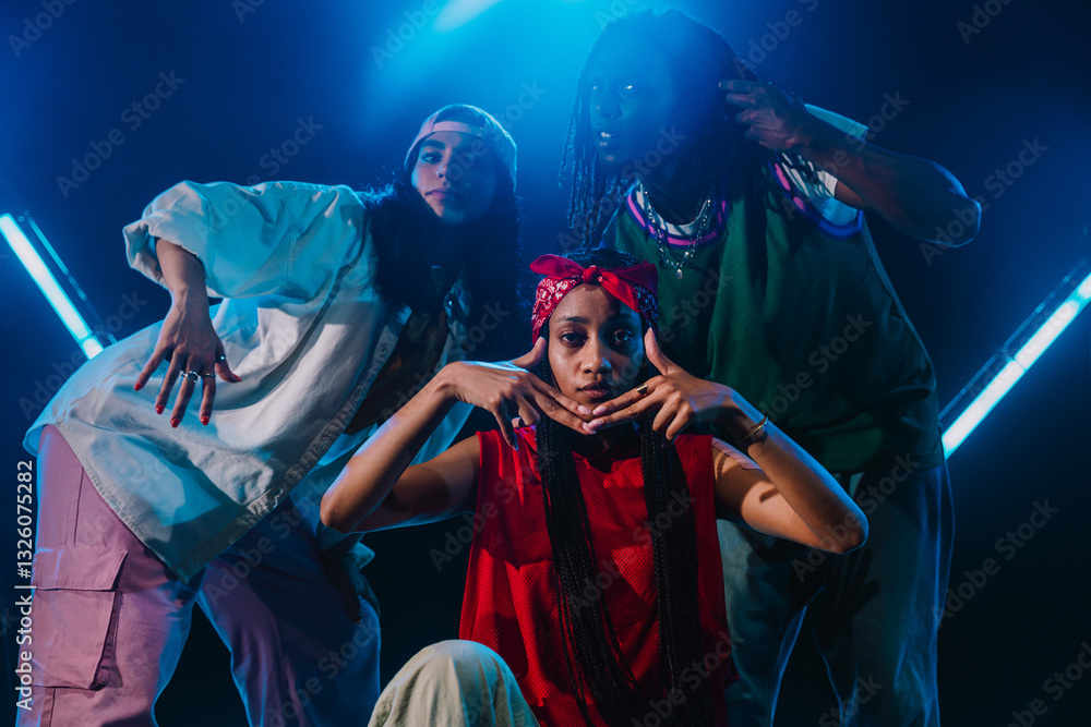 Fototapeta premium Group of hip hop dancer dancing together in a moody studio with tube neon lights.