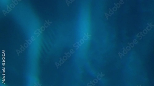 Slow-moving blue light reflections shimmer on the water’s surface, creating a mesmerizing abstract background. A texture, backdrop, or visual design element. A soothing and atmospheric video