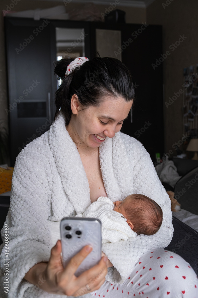 Mother Smiling at Smartphone with Newborn Baby