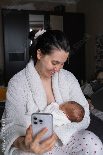 Obraz na płótnie Mother Smiling at Smartphone with Newborn Baby w salonie