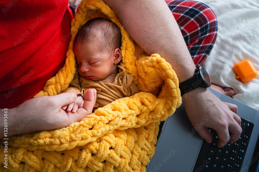 Man multitasking with laptop and baby on bed