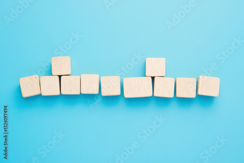 Cubes arranged with wooden letter tiles on a blue background.