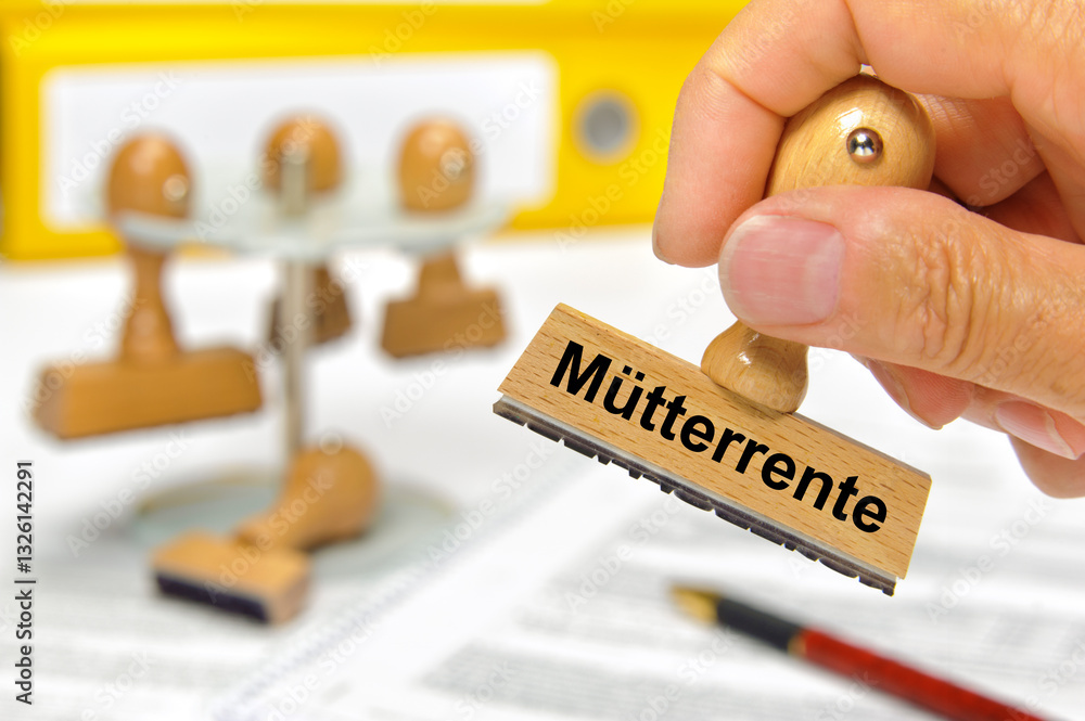 Ein Holzstempel in der Hand ist beschriftet mit dem Aufdruck Mütterrente