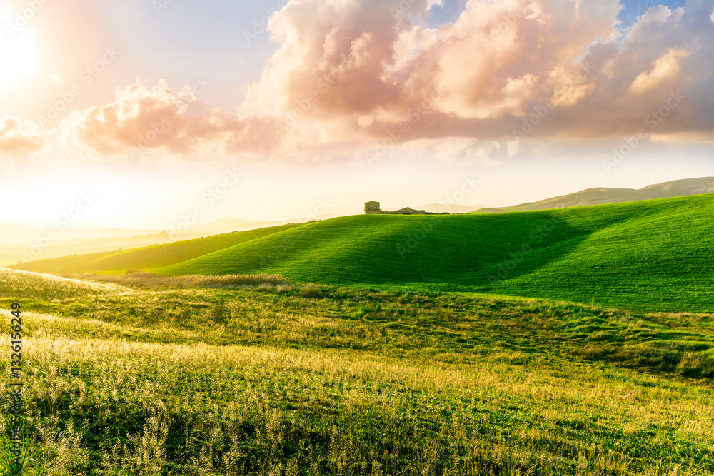 Fototapeta premium amazing sunset among green spring hills in highland farm with castle , mountains and picturesque colorful sunset on background of landscape