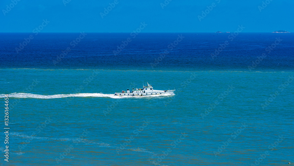 Naklejka premium A Majestic Boat Navigating the Vibrant Blue Ocean Waters