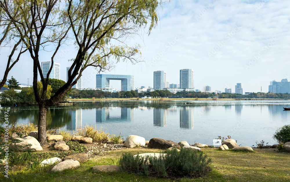 Fototapeta premium Tranquil Lakeside Urban Landscape with Reflections and Modern Architecture