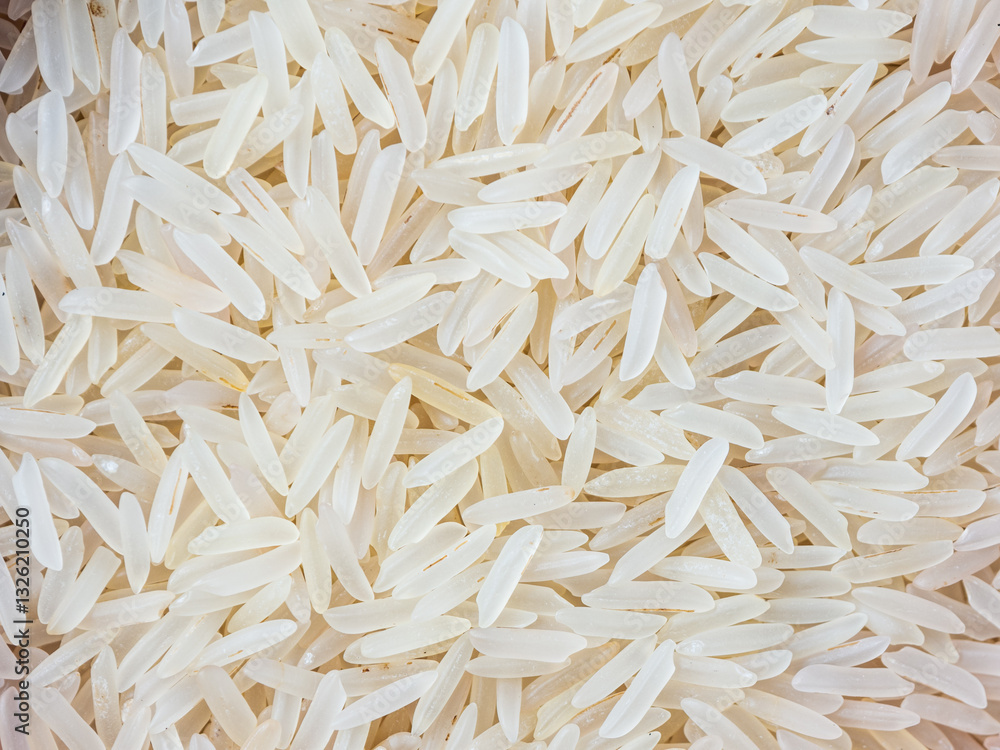 Close-up shot of dry, uncooked long grain basmati rice. Grains are slender and translucent, natural texture. Close-up shot of dry, uncooked long grain basmati rice. Grains are slender and translucent, natural texture.