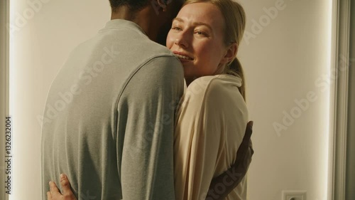 A tender and emotional close-up of a content woman with her eyes closed, enjoying a warm embrace from her partner.