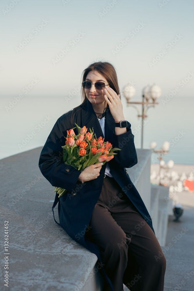Fototapeta premium Happy woman sniff tulip flowers at the city street