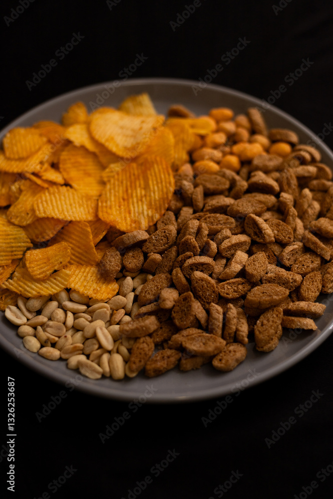 Fototapeta premium plate with beer snacks on black background