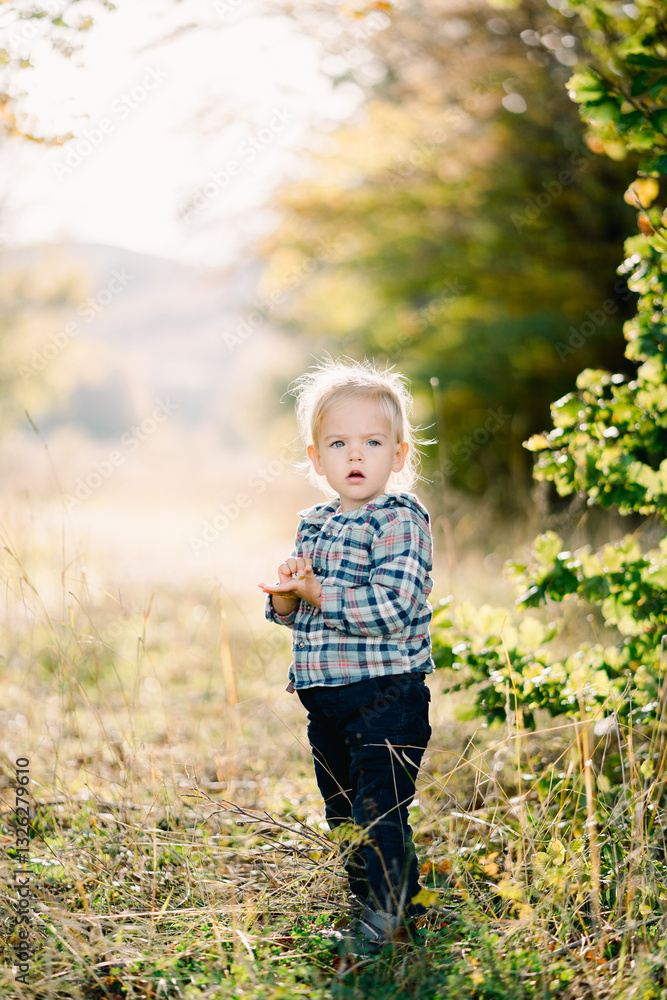 Little girl stands half-turned with her mouth open in a clearing Little girl stands half-turned with her mouth open in a clearing