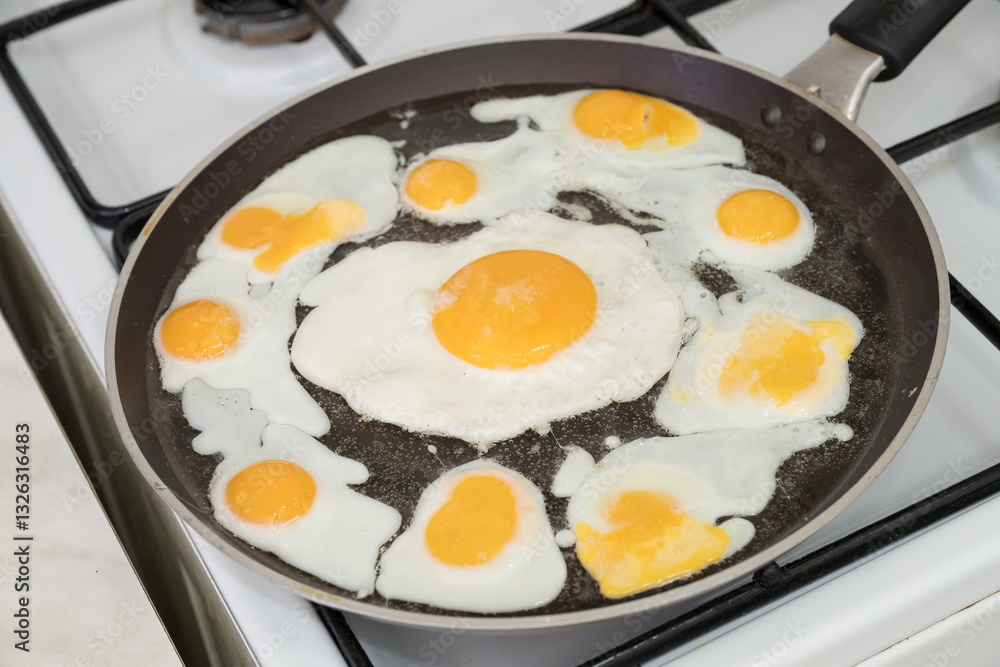 Chicken egg and 9 quail eggs in frying pan. Chicken egg and 9 quail eggs in frying pan.