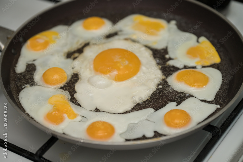 Chicken egg and 9 quail eggs in frying pan. Chicken egg and 9 quail eggs in frying pan.