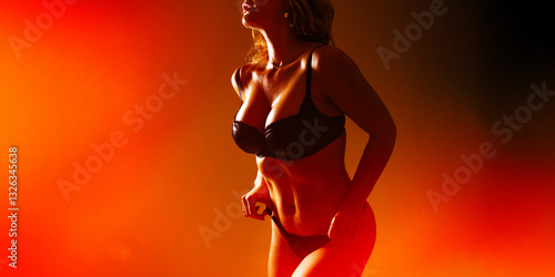 Photo of a woman's silhouette in rich red and orange studio lighting