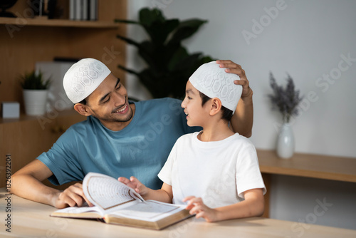 Wallpaper Mural Muslim father and son in mosque praying and reading holly book Quran together. Happy learning Islamic education concept. A man pround with hiis boy, looking each other and smile. Torontodigital.ca