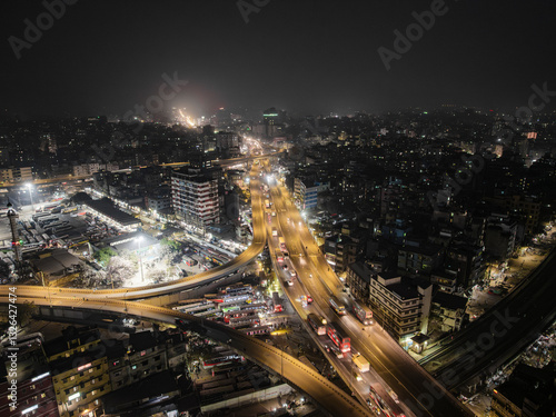 Aerial view of bustling cityscape with illuminated buildings and busy traffic at night, Gendaria, Dhaka, Bangladesh.