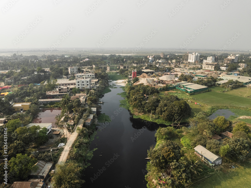 Aerial view of Brahmaputra River winding through a serene urban landscape with residential houses and greenery, Duptara, Araihazar, Dhaka, Bangladesh. Aerial view of Brahmaputra River winding through a serene urban landscape with residential houses and greenery, Duptara, Araihazar, Dhaka, Bangladesh.