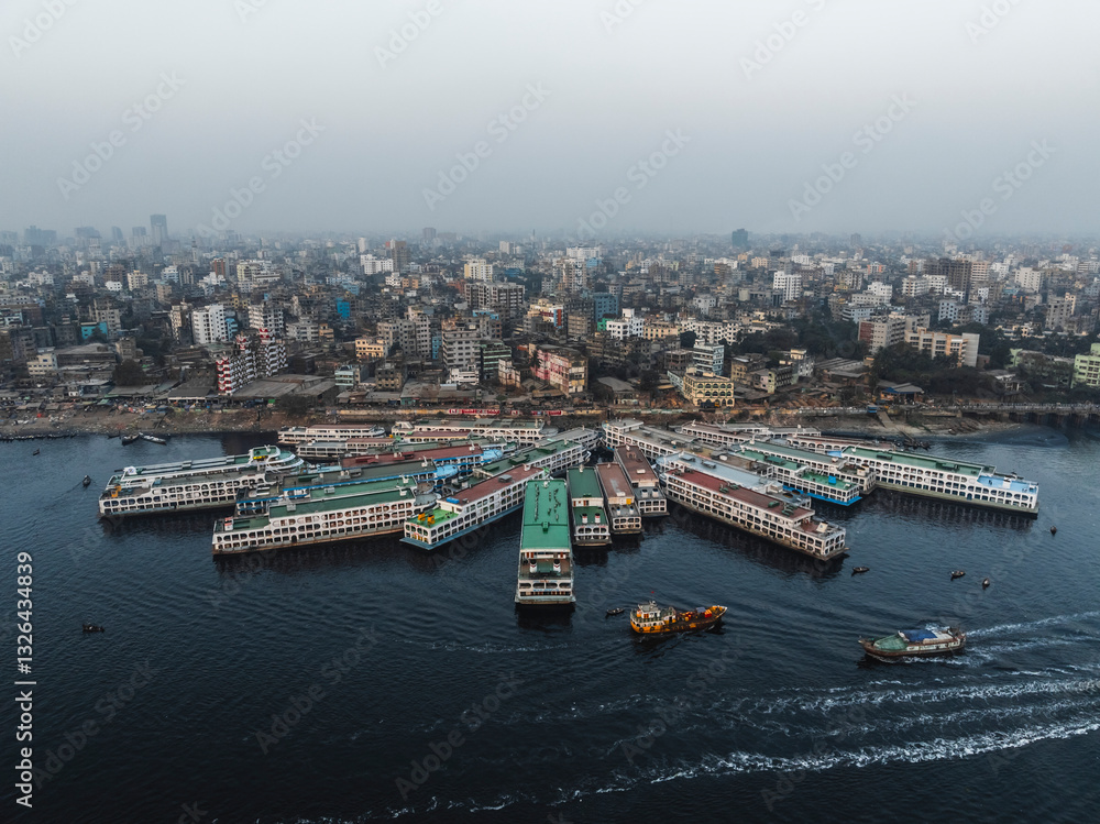 Aerial view of Sadar Ghat and the Buriganga River with modern buildings and boats, Subhadya, Keraniganj, Dhaka, Bangladesh. Aerial view of Sadar Ghat and the Buriganga River with modern buildings and boats, Subhadya, Keraniganj, Dhaka, Bangladesh.