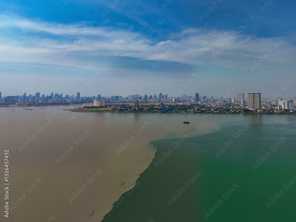 Aerial view of the serene meeting of the Mekong and Tonle Sap rivers with a beautiful cityscape and skyline, Akreiy Ksatr, Kandal, Cambodia. Aerial view of the serene meeting of the Mekong and Tonle Sap rivers with a beautiful cityscape and skyline, Akreiy Ksatr, Kandal, Cambodia.
