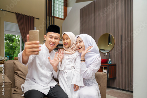 Wallpaper Mural Portrait of the Indonesian Muslim family with mobile phone taking selfie or video call while celebrating Eid Mubarak. Concept of Happy Lebaran, Eid Al Fitr, Idul Fitri, and Ramadan Mubarak celebration Torontodigital.ca