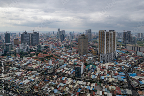 Aerial view of a vibrant urban skyline with high-rise buildings and crowded rooftops under a cloudy sky, Prampi Makara District, Phnom Penh, Cambodia. photo