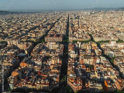 Aerial view of beautiful historic cityscape with dense rooftops and bustling streets, Gracia, Barcelona, Spain.