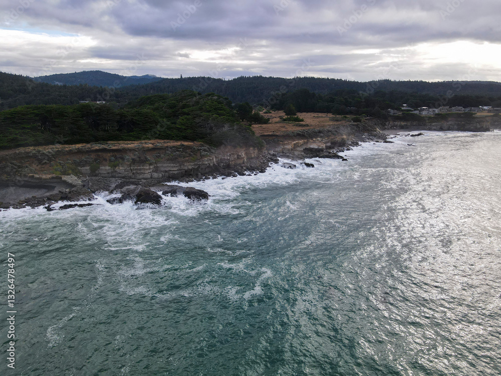 Aerial view of rugged coastline with crashing waves and steep cliffs, The Sea Ranch, California, United States. Aerial view of rugged coastline with crashing waves and steep cliffs, The Sea Ranch, California, United States.