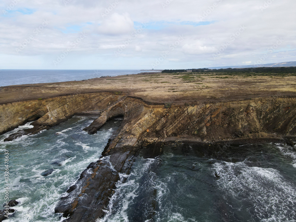 Aerial view of rugged cliffs and powerful waves along the scenic pacific coast, Point Arena, California, United States. Aerial view of rugged cliffs and powerful waves along the scenic pacific coast, Point Arena, California, United States.